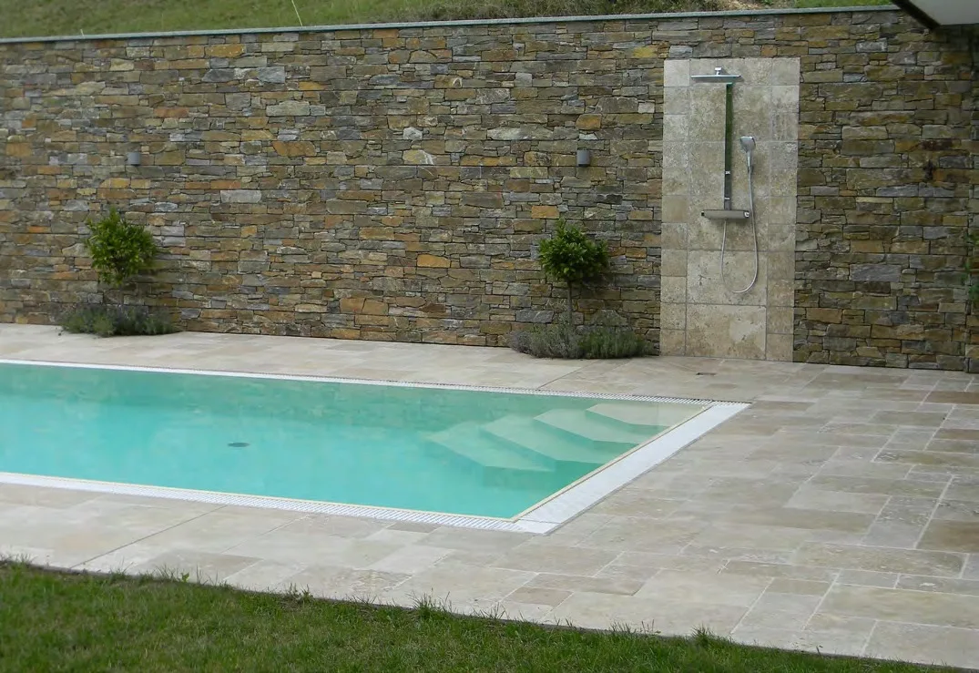 Pool mit Umrandung und Terrasse aus Travertin Nut im Verband