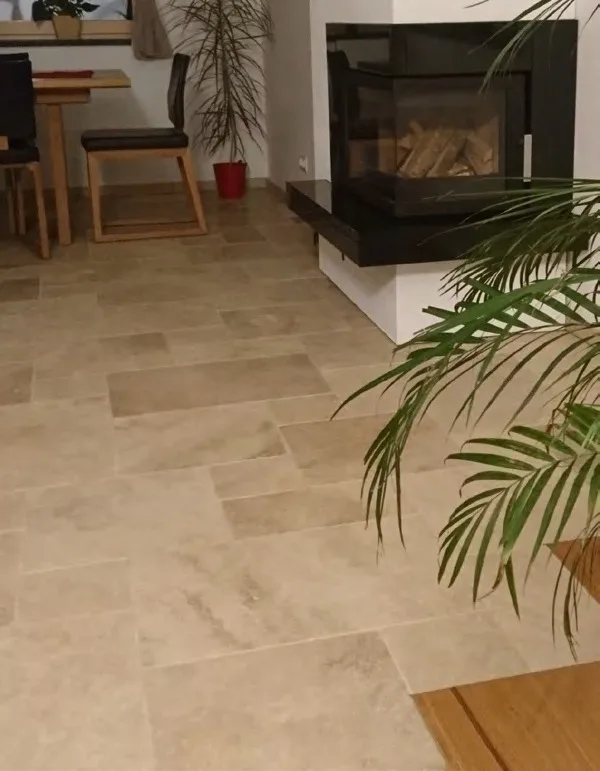 Wohnraum mit Boden aus Travertin Beige im Römischen Verband neben einem Kamin